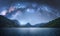 Arched Milky Way over the mountains and blue sea at night