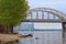 Arched railway bridge. High-rise buildings in the background. Picturesque landscape of Dnipro River