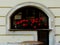 Arched restaurant window with decaying sill and red geraniums