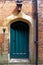 Arched rustic wooden door in a stone wall at Hampton Court Palace