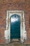 Arched rustic wooden door in a stone wall at Hampton Court Palace