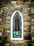 Arched Stained Glass Window in Stone Wall