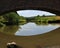 Arched stone bridge over water with reflection of stone