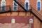 arched white windows behind back alley fire escape stairs