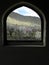 Arched window in an old house. The window to the spring is open and the trees are in bloom. Central cities of Iran.