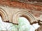 Arched window openings of a destroyed abandoned building. Broken vintage arches of a ruined abandoned ancient building