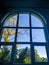 Arched window with view to autumnal landscape, bright sunshine. View through the window in autumn