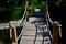 Arched wooden bridge in the park. the railing posts are connected by a strong jute rope. Knots finished with a rope work of a Japa