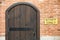 Arched wooden door on brick wall