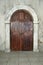 Arched wooden door in a stone wall