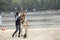 An archer teaching young woman archery on the sandy beach of the river, arrows, quiver and bow