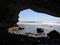 The Arches framing beach and waves crashing along western shore of Newfoundland