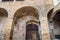 Arches in a well-aged brick building with medieval frescos in the Italian village of San Gimignano in Tuscany, Italy