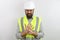 Architect with beard wearing hardhat and reflecting jacket touching painful palm hand