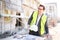 An architect / civil engineer at work on a construction site, holding plans in hand