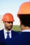 Architect with confident smile in formal wear and orange helmet.