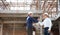 Architect and construction worker engineers shaking hands while working at outdoor construction site