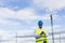 Architect or Engineer using his mobile phone on the construction site. Job concept. Wearing protective clothes. Crane on the