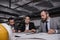 architects and engineers in suits working at table with blueprints