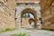 Architectural arch made of red bricks wall with blue sky background in iznik.