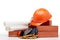 Architectural blueprints, stack of bricks, masonry trowel,  construction hard hat on white background. Construction concept