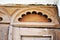 Architectural detail in pink plaster, half arch with dÃ©cor frame over door frame, background texture
