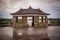 Architectural details - Gazebo made of stone in an oriental style behind which is a waterfall. dramatic tone, mystical scene.