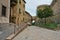 Architectural details of old houses at narrow street of Volterra with Medici fortress in background, Tuscany