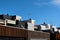 Architectural details showing a row of modern town house apartments on a sunny day and a blue sky.