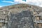 Architectural details of the walls of  significant Mesoamerican pyramids and green grassland located at at Teotihuacan, an ancient