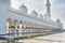 Architectural details of  White Grand Mosque built with marble stone against cloudy sky, also called Sheikh Zayed Grand Mosque in