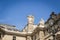 Architectural landscape of the roof and statues of the facade of the Louvre Museum in Paris from the place of pyramids