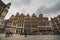 Architecture and lifestyle: people stand by an opulent building facade in the noble Bruxelles Grand Place, Brussels