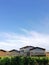 Architecture of a Rioja winery with its vineyards below and the blue sky with clouds above