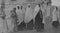 Archival monochrome photo showing a group of Arab women in traditional dress, taken in the City of Hebron, Palestine in 1920.