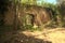 Archway in a brick wall of an abandoned fortification in the middle of a forest on a sunny day in the italian countryside