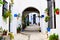 Archway in a courtyard with plants lining the perimeter and two arched arches at each in, Spain