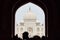 Archway of main gateway in Taj Mahal entrance with tourists silhouettes, view to Taj Mahal mausoleum