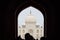 Archway of main gateway in Taj Mahal entrance with tourists silhouettes, view to Taj Mahal mausoleum