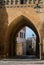 An archway of a mudejar style tower, old buildings and a lantern at the wall at medieval town Teruel