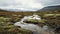 Arctic Expedition: A Grassy Hillside With Flowing Water In Norwegian Nature Style