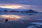 Arctic Glow reflecting in Whalers Bay, Deception Island, Antarctica with Zodiac