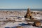 Arctic landscape - an Inuksuk or Inukshuk landmark on a snow covered arctic tundra in Nunavut on a clear sunny day