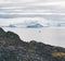 Arctic nature landscape with icebergs in Greenland icefjord with midnight sun sunset sunrise in the horizon. Early