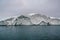 Arctic nature landscape with icebergs in Greenland icefjord with midnight sun sunset sunrise in the horizon. Early