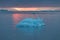 Arctic nature landscape with icebergs in Greenland icefjord with midnight sun sunset / sunrise in the horizon.  Early morning