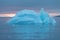 Arctic nature landscape with icebergs in Greenland icefjord with midnight sun sunset / sunrise in the horizon.  Early morning