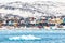 Arctic snow city panorama with colorful Inuit houses on the rock