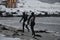 Arctic surfers running on beach after surfing