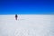 Arctic winter landscape - view of a snowy desert field with a walking man